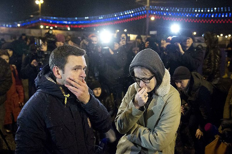 Russian opposition leaders Ilya Yashin (left) and Ksenia Sobchak wait in Moscow as police investigate the death Friday of fellow opposition leader Boris Nemtsov. 