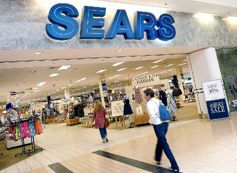 Shoppers enter a Sears store in Peabody, Mass., in this file photo. Sears Holdings, operator of Sears and Kmart stores, reported a $159 million fourth-quarter loss on Thursday. 