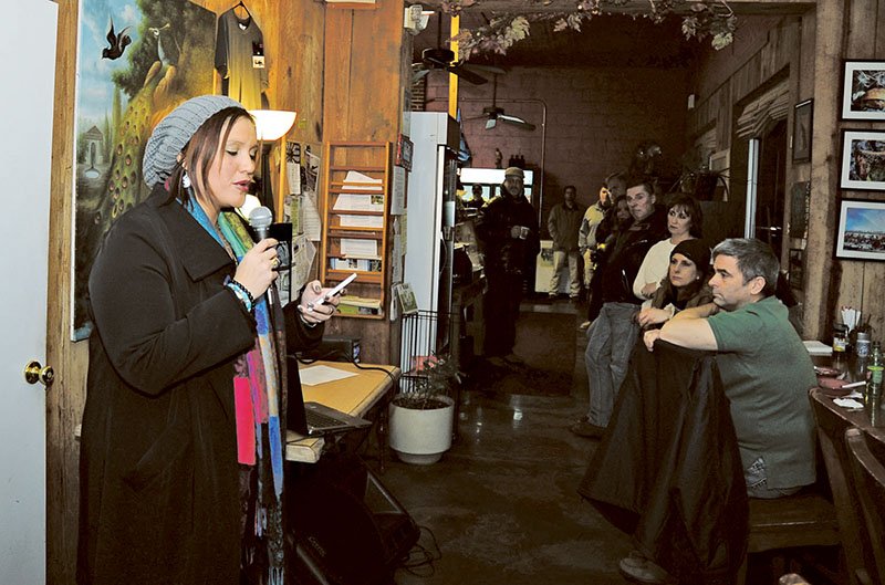 The Sentinel-Record/Mara Kuhn HOTEL POEM: Kai Coggin reads a poem she wrote about the Majestic Hotel during an event at Park Island Cafe to commemorate the anniversary of the Feb. 27, 2014, fire that destroyed the oldest part of the hotel complex.