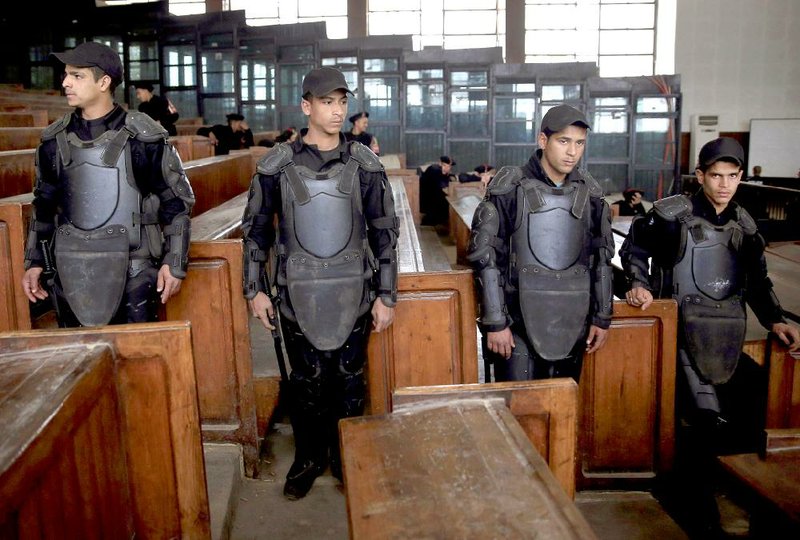 Egyptian policemen stand guard in front of the courtroom defendant's cage during a verdict hearing on a case that stems from clashes near the Muslim Brotherhood's headquarters on June 30, 2013, four days before the ouster of Islamist President Mohammed Morsi, that left 11 people dead and 91 wounded, in Cairo, Egypt, Saturday, Feb. 28, 2015. The Egyptian court sentenced four members of the banned Muslim Brotherhood organization to death and 14 to life in prison. Some 22,000 people have been arrested since Morsi's ouster, including most of the Brotherhood's leaders, as well as non-Islamist activists swept up by police during protests. (AP Photo/Hassan Ammar)