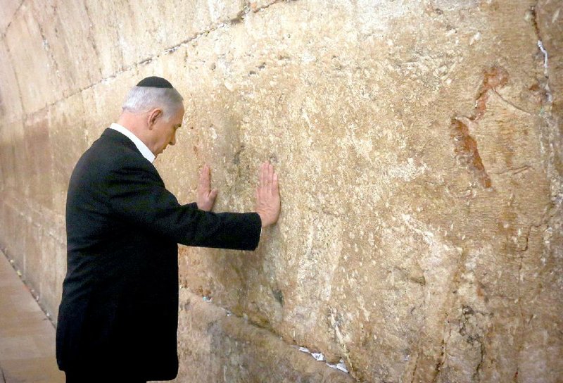 Israeli Prime Minister Benjamin Netanyahu prays at the Western Wall, the holiest site where Jews can pray, in Jerusalem's Old City, Saturday Feb. 28, 2015. (AP Photo/Marc Sellem, Pool)