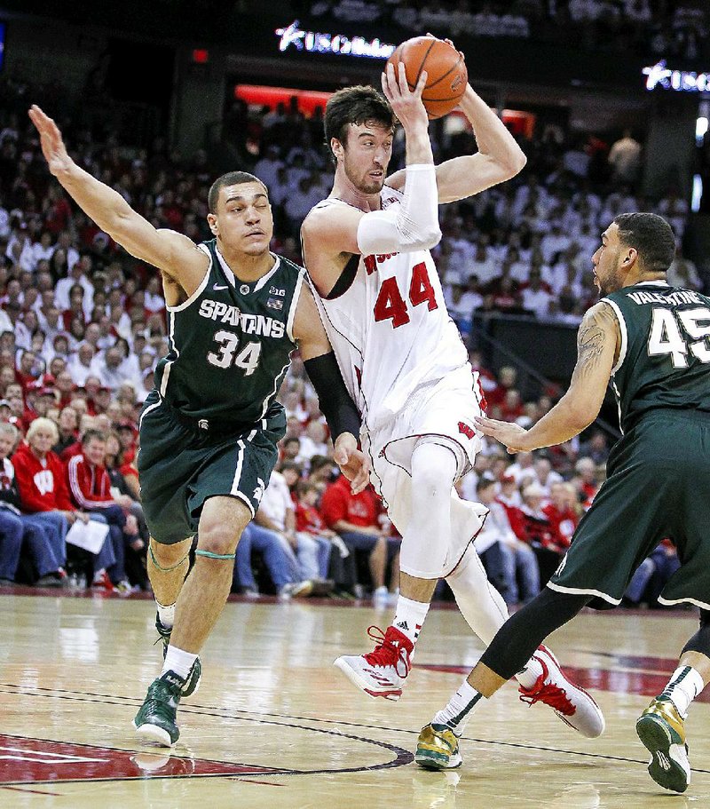 CORRECTS NAME TO SCHILLING NOT WOLLENMAN Wisconsin's Frank Kaminsky (44) passes between Michigan State's Gavin Schilling (34) and Denzel Valentine during the second half of an NCAA college basketball game, Sunday, March 1, 2015, in Madison, Wis. Wisconsin won 68-61. (AP Photo/Andy Manis)