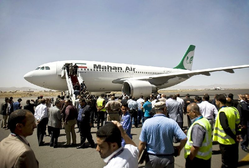 Yemeni airport, security and transportation officials greet a plane from the Iranian private airline, Mahan Air after it lands at the international airport in Sanaa, Yemen, Sunday, March 1, 2015. The first direct flight from Iran to the rebel-held Yemeni capital arrived, Sunday, an Airbus 310 carrying Iranians including aid workers from the Iranian Red Crescent as Yemen's Shiite rebels formalize ties with the regional Shiite powerhouse. The rebels, who overran the capital, Sanaa, last September, are widely believed to have support from Iran, a claim they frequently denied. (AP Photo/Hani Mohammed)