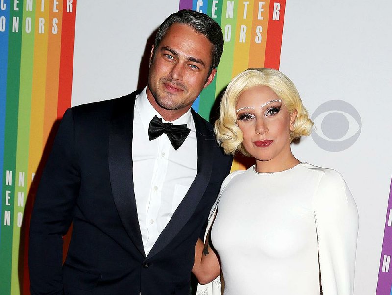 FILE - In this Dec. 7, 2014 file photo, Taylor Kinney and Lady Gaga attend the 37th Annual Kennedy Center Honors in Washington. Lady Gaga announced on her Instagram account Monday, Feb. 16, 2015 that she and Kinney are engaged. Her representative confirmed. Kinney stars in the NBC series “Chicago Fire” and also had a role in the film “Zero Dark Thirty.” Gaga’s hits include “Poker Face,” “Bad Romance” and “Applause.” She recently won her sixth Grammy Award this month for her album with Tony Bennett, “Cheek to Cheek.” (Photo by Greg Allen/Invision/AP, File)