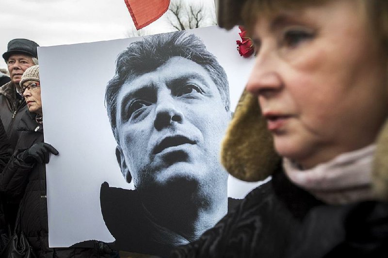 People carry a placard with the image of opposition leader Boris Nemtsov who was gunned down on Friday, during a march, in St.Petersburg, Russia, Sunday, March 1, 2015. Thousands converged Sunday in central Moscow to mourn veteran liberal politician Boris Nemtsov, whose killing on the streets of the capital has shaken Russia’s beleaguered opposition. They carried flowers, portraits and white signs that said “I am not afraid.”  (AP Photo/Elena Ignatyeva)