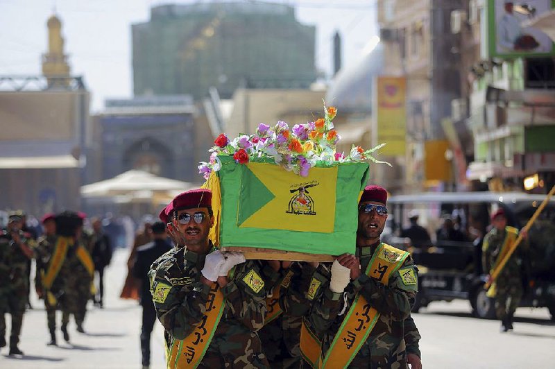 Iraqi Hezbollah fighters carry the coffin of their comrade, Ali Mansour, who his family says was killed in Tikrit fighting Islamic militants, during his funeral procession, in the Shiite holy city of Najaf, 100 miles (160 kilometers) south of Baghdad, Iraq, Monday, March 2, 2015. Backed by allied Shiite and Sunni fighters, Iraqi security forces on Monday began a large-scale military operation to recapture Saddam Hussein's hometown from the Islamic State extremist group, state TV said, a major step in a campaign to reclaim a large swath of territory in northern Iraq controlled by the militants. (AP Photo/Jaber al-Helo)