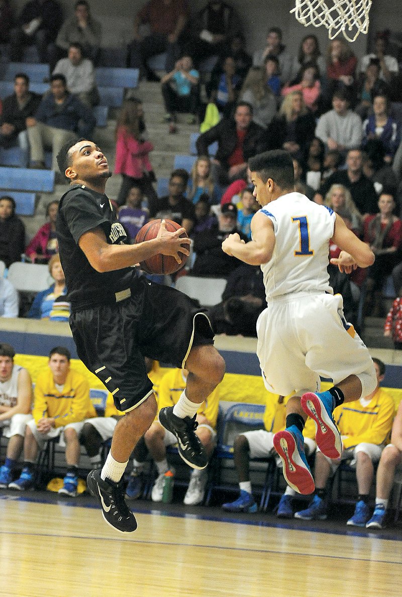 The Sentinel-Record/Mara Kuhn RISING TROJANS: Hot Springs guard Anthony Goffigan, left, goes up for a layup while defended by Lakeside guard Chris Babb during the first half Thursday at Lakeside Athletic Complex. The Trojans, riding a 12-game winning streak, and Lady Trojans, on a 14-game streak, are both No. 1 seeds from the 5A-South for the second consecutive season, the girls beginning state play at 1 p.m. Wednesday against Greenbrier at Greene County Tech and the boys following at 2:30 against Clarksville.