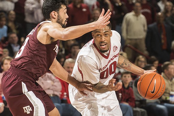 Rashad Madden, Arkansas senior, drives to the basket as Alex Robinson, Texas A&M freshman, defends in the second half Tuesday, Feb. 24, 2015 at Bud Walton Arena in Fayetteville.