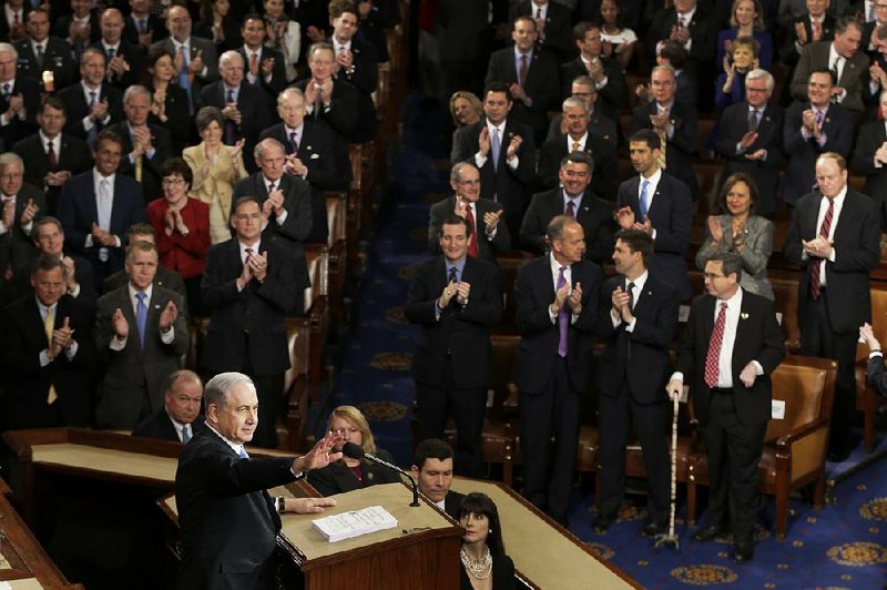 Israeli Prime Minister Benjamin Netanyahu pauses during one of dozens of standing ovations during his speech Tuesday to a joint session of Congress. Standing on the front row at left is Sen. John Boozman, R-Ark.; across the aisle three chairs down in the second row is Sen. Tom Cotton, R-Ark. 