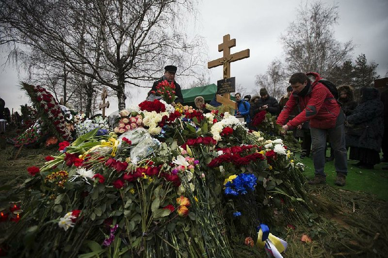 People lay flowers at Boris Nemtsov’s grave after a burial ceremony at Troekurovskoye cemetery in Moscow on Tuesday. 