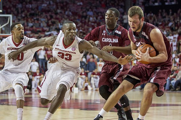 South Carolina forward Mindaugas Kacinas, right, pulls down a rebound as Arkansas forward Moses Kingsley, left, attempts to steal during the first half of an NCAA college basketball game on Tuesday, Feb. 3, 2015, in Fayetteville, Ark. (AP Photo/Gareth Patterson)