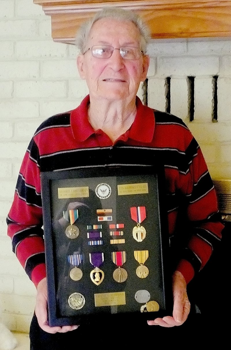 Lynn Atkins/The Weekly Vista Glen Huffman holds the shadowbox that contains his metals from World War II, including a Purple Heart. He is a survivor of the first U.S.S. Samuel B. Roberts and the Battle of the Leyte Gulf.