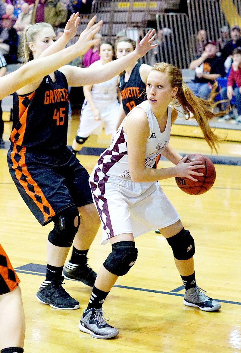 File Photo by Randy Moll Mallory Morris, Gentry junior, looks to pass off the ball while guarded by Amanda Pinter, Gravette junior, during district tournament play in Springdale on Feb. 19.