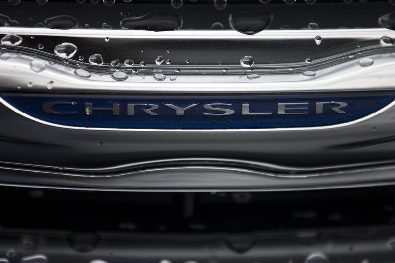 In this Dec. 2, 2014 photo, a Chrysler minivan sits under rain at a car lot in San Diego. Major automakers report vehicle sales for February on Tuesday, March 3, 2015.