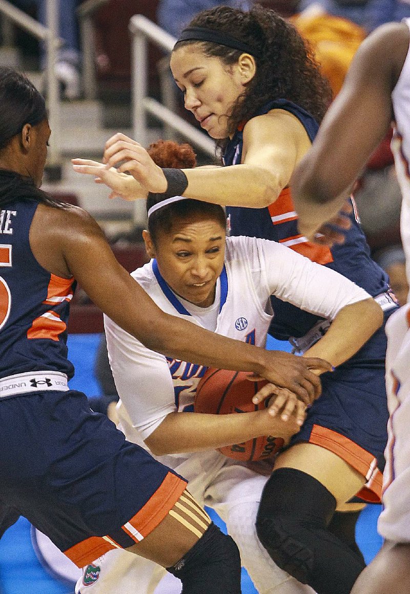 Florida’s Cassie Peoples is sandwiched by Auburn’s Jazmine Jones (right) and Neydja Petithomme (left) during Wednesday’s game at the SEC Women’s Tournament in North Little Rock. 
