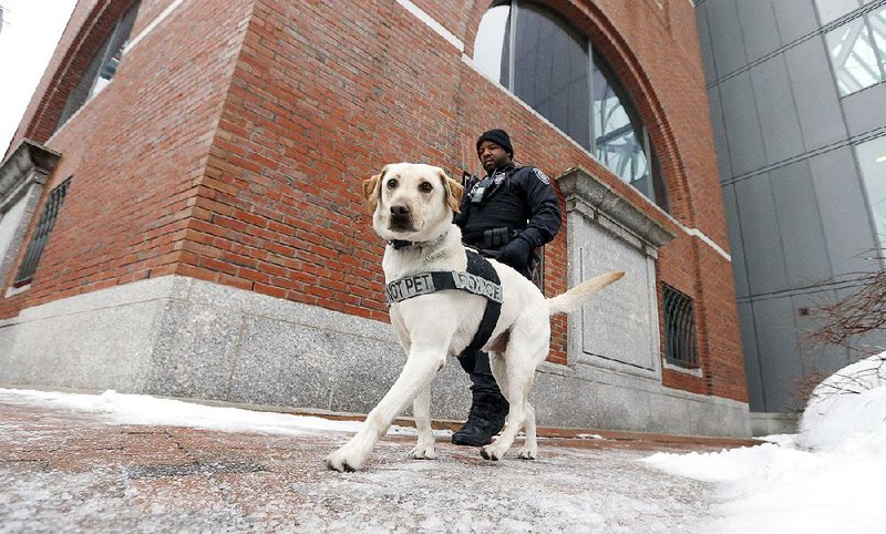 A police officer patrols with his dog Wednesday outside the federal courthouse in Boston as Dzhokhar Tsarnaev’s trial in the Boston Marathon bombings gets underway. 