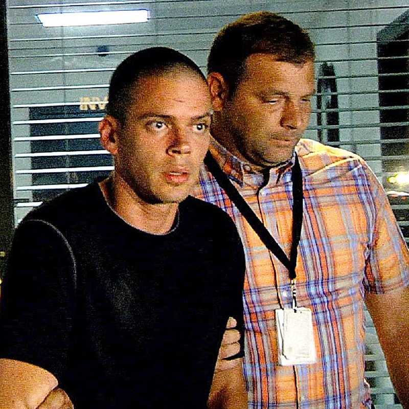 In this file photo Arron Lewis (L) is escorted from the Pulaski County Sheriff's department by investigators after being interrogated, September 30, 2014.