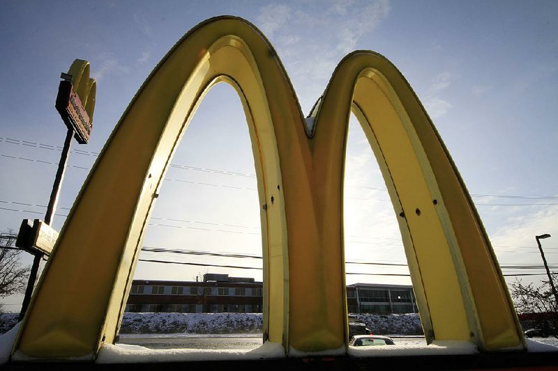 Snow covers the McDonald’s Golden Arches sign at a restaurant in Robinson Township, Pa., in January. The hamburger chain said Wednesday that it will start using chicken raised without antibiotics. 