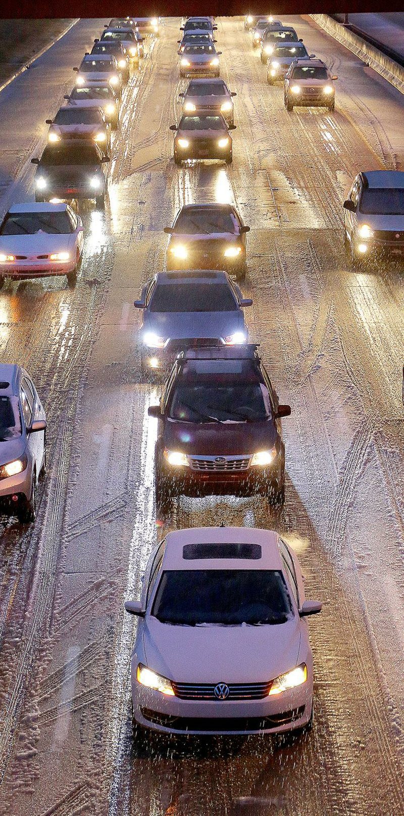 As sleet falls just after 6 p.m. Wednesday, traffic in downtown Little Rock inches along Interstate 630 near Center Street. The precipitation was expected to later change over to snow.