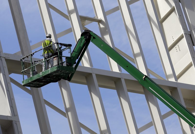 In this Tuesday, Feb. 3, 2015 photo, a worker paints a draw bridge along the Miami River in downtown Miami. The Federal Reserve releases its latest Beige Book survey of economic conditions on Wednesday, March 4, 2015.