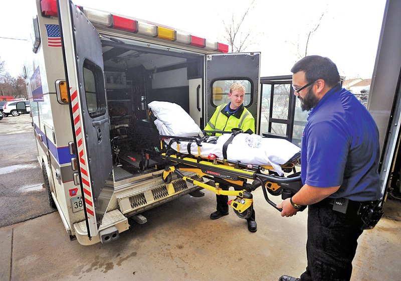 NWA Democrat-Gazette/Michael Woods &#8226; @NWAMICHAELW Seth Mans (left) and Jason Fisher, both Central Emergency Medical Service EMTs, get their ambulance ready for their next call Tuesday at their headquarters in Fayetteville. Central EMS will be getting another ambulance to add to its fleet.