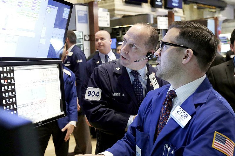 Trader Michael Urkonis (center) and specialist Paul Cosentino (right) work Thursday on the floor of the New York Stock Exchange. 