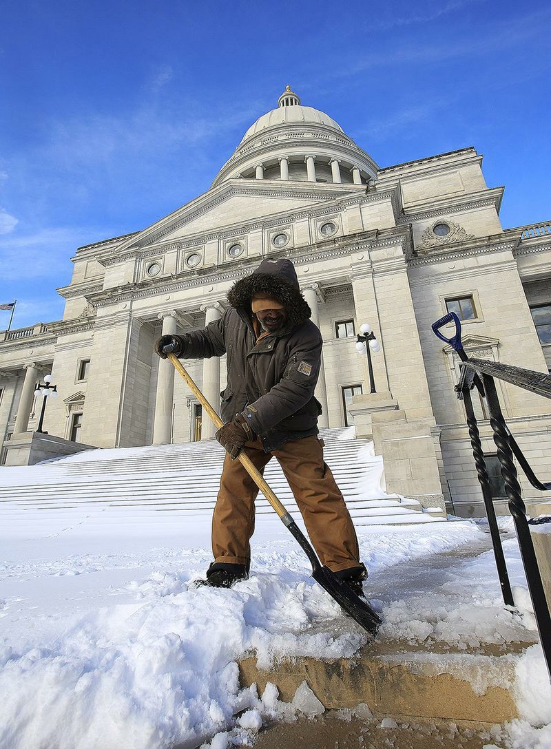 Both houses of the Legislature put in a full day’s work Thursday, in spite of the snowfall of the night before. Frank Cusmano, a groundskeeper at the state Capitol, did his part by clearing a path on the front steps.