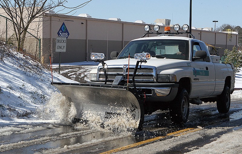 The Sentinel-Record/Richard Rasmussen PLOWING AHEAD: A city plow truck clears slush from Lakeshore Drive Thursday morning. Sunlight turned the several inches of ice and snow that fell Wednesday and early Thursday to slush by late morning.