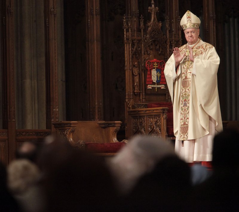 In this April 12, 2009 file photo, Cardinal Edward Egan receives a standing ovation after speaking to worshipers during Easter Mass in New York. Egan, the former archbishop of New York, died of cardiac arrest Thursday, March 5, 2015, in New York. He was 82. 