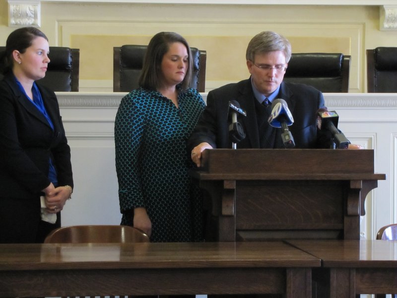 Attorney Jennifer Wells looks on as state Rep. Justin Harris and his wife Marsha speak at a news conference about "re-homing" two daughters they adopted. 