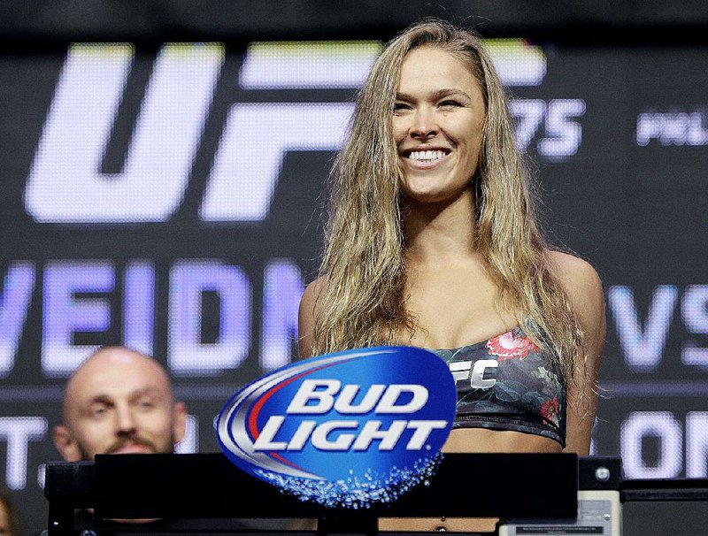 FILE - In this July 4, 2014, file photo, Ronda Rousey stands on the scale during a weigh-in for the UFC 175 mixed martial arts event at the Mandalay Bay in Las Vegas. Rousey has dominated every challenger in her two-year reign as the UFC's only women's bantamweight champion. Cat Zingano still believes she has a legitimate shot at Rousey's belt in UFC 184 on Saturday, Feb. 28, 2015, in Los Angeles. (AP Photo/John Locher, File)