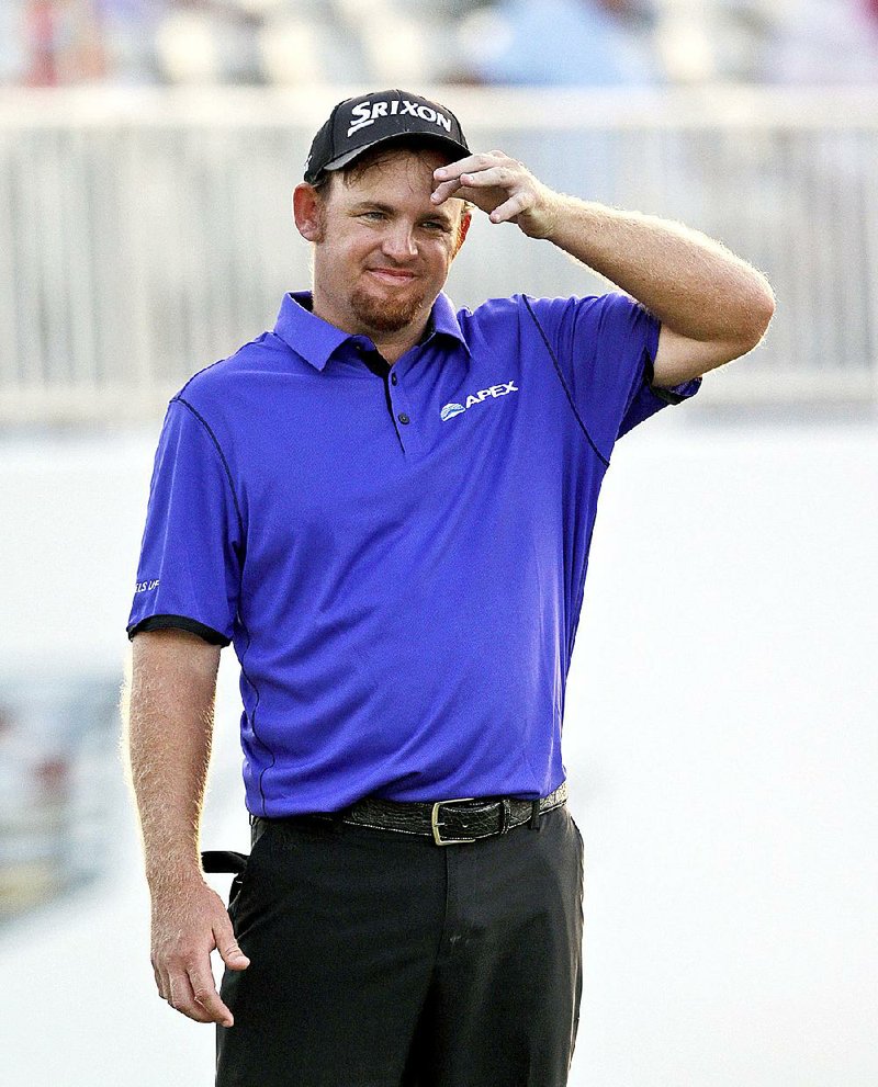 J.B. Holmes wipes his brow as he waits to putt on the 18th hole during the second round of the Cadillac Championship golf tournament, Friday, March 6, 2015, in Doral, Fla. (AP Photo/Wilfredo Lee)