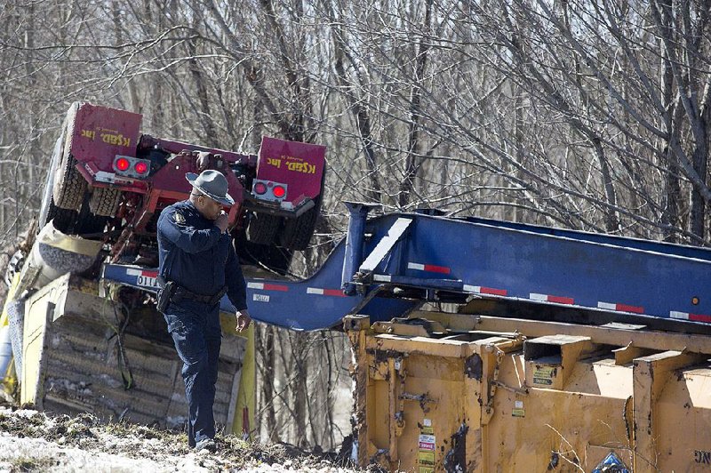 Arkansas Democrat-Gazette/MELISSA SUE GERRITS - 03/06/2015 - An Arkansas State Trooper looks at an overturned 18 wheeler that went off the shoulder on 30 westbound before the 65th Street Exit March 6, 2015. The driver was unharmed. 