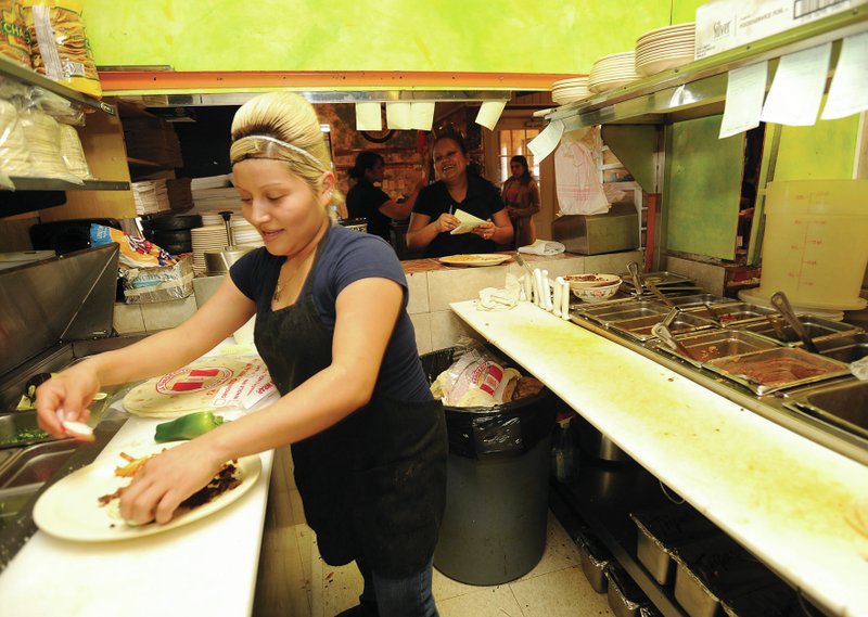  NWA Democrat-Gazette/ANDY SHUPE Bel&#233;n Ramirez cooks food Friday at El Cunado Taqueria in Springdale. Team Springdale is preparing a map of the various taquerias in town called the &#8220;Taco Tour.&#8221;