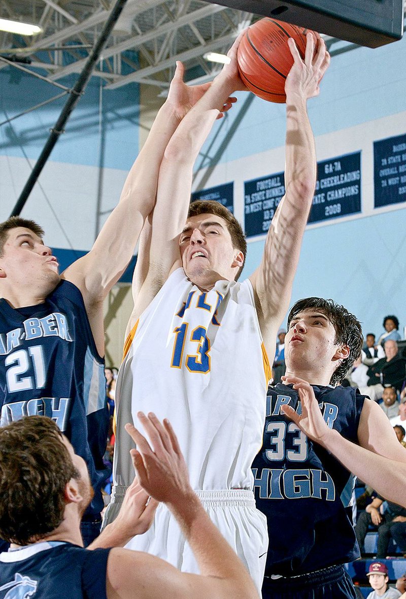 NWA Democrat-Gazette/BEN GOFF -- 03/08/15 Samuel Dunkum (13) of North Little Rock wins a rebound against Avery Benson (21) and J.P. Brandon of Springdale Har-Ber during the 7A State Tournament game in Wildcat Arena at Springdale Har-Ber on Sunday Mar. 8, 2015. 