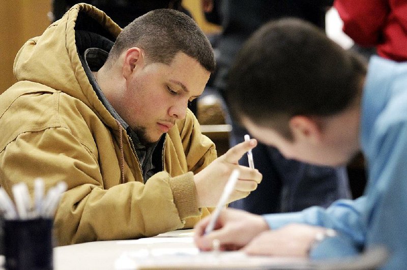 A job seeker completes applications during a public-safety job fair at City Hall in Saginaw, Mich., in January. The number of open jobs rose 2.5 percent to nearly 5 million in January, the Labor Department said. 