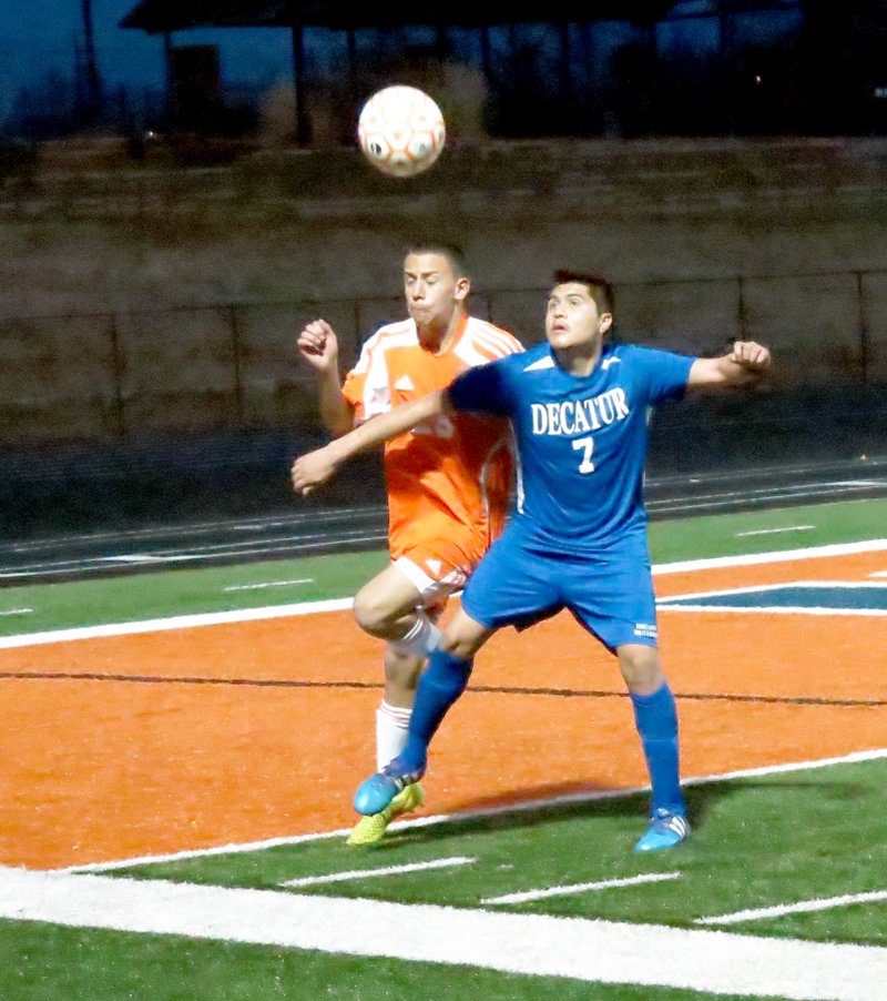 Photo by Mike Eckels Antonio Resales (Decatur #7) and a Rogers Heritage player battle it out for the ball near the west sideline during the March 3 soccer match in Rogers. Resales was able to gain possession of the ball and passed it off to one of his teammates.