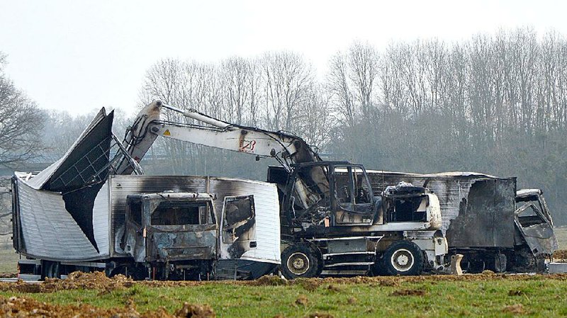 Abandoned burned-out vans sit near a French highway exit about 30 miles from the site where armed bandits had ambushed the jewel-hauling vans. 