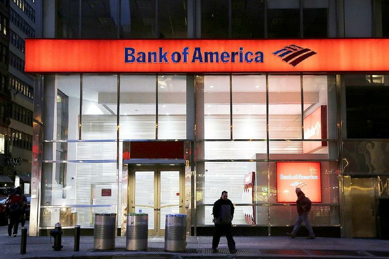 People walk past a Bank of America branch in January in New York. The Federal Reserve announced Wednesday that it is ordering Bank of America to revise its plans for increasing dividends or buying back stock, saying there are gaps in its risk planning. 