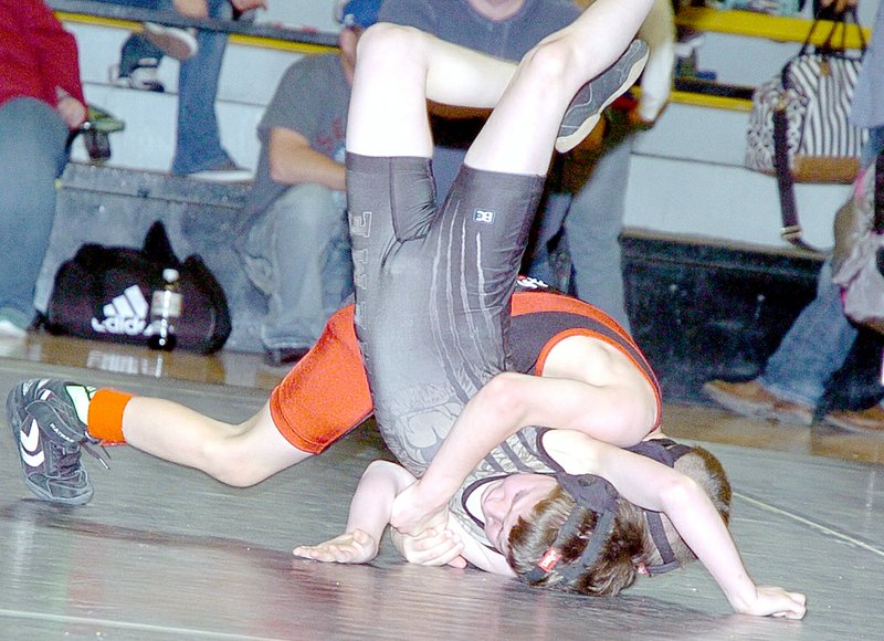 RICK PECK MCDONALD COUNTY PRESS McDonald County youth wrestler Ryder Martin takes Wyatt Friend, of Neosho to the mat during his 7-0 win in a district championship match.