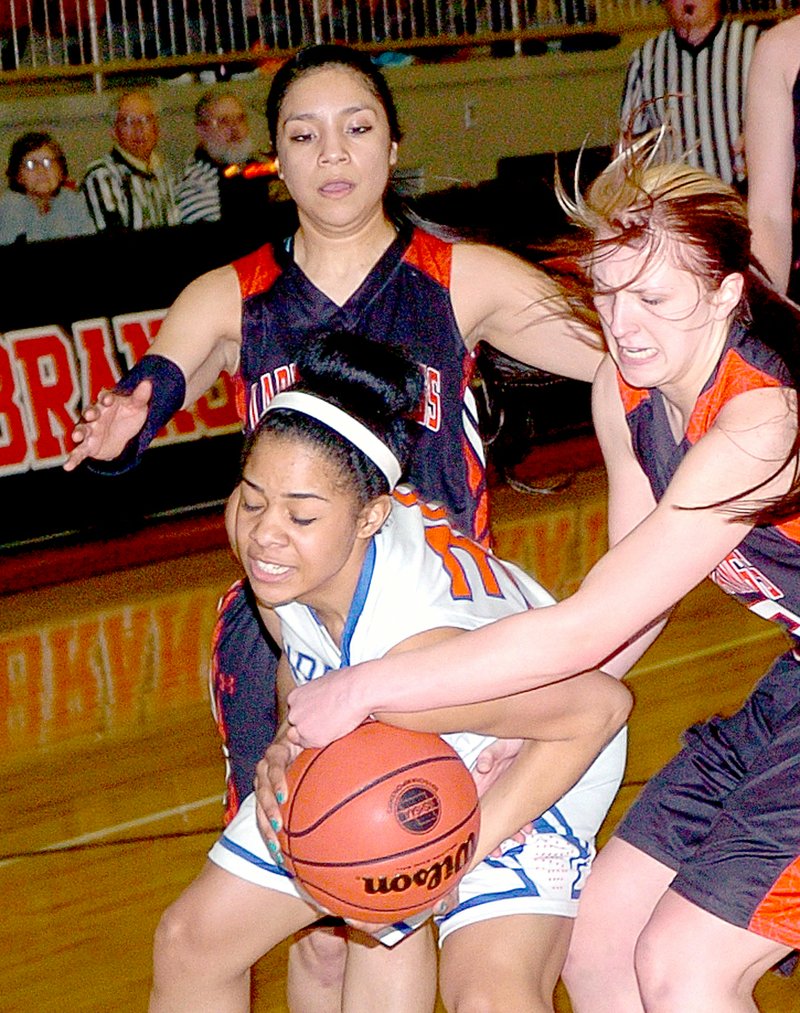 RICK PECK MCDONALD COUNTY PRESS McDonald County&#8217;s Baili Nelson tries to take the ball away from Hillcrest&#8217;s Kaycee Gerald during the Lady Mustangs 51-41 loss Tuesday night in the Missouri Class 4 Sectionals at Branson High School.