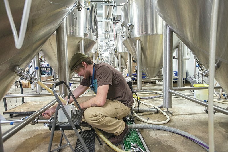 NWA Democrat-Gazette/ANTHONY REYES Richard Bell, assistant brewer, lead cellarman for Core Brewing &amp; Distilling Co., prepares tanks for filtering Wednesday at the brewery in Springdale. The company is looking at two new pub locations in downtown Springdale and near Har-Ber Meadows.