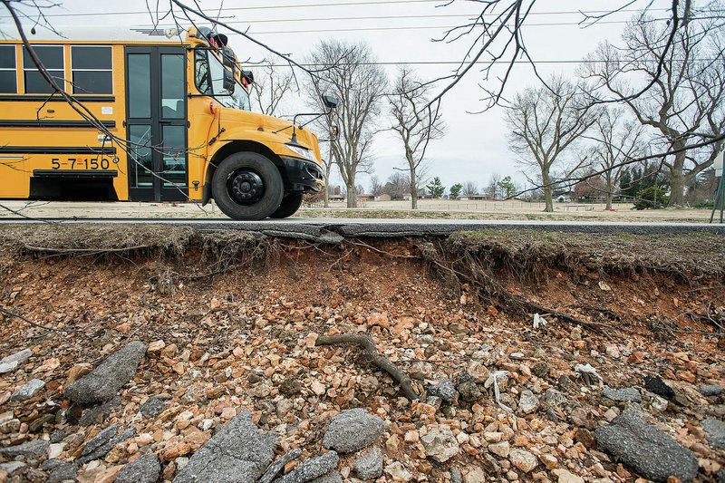 NWA Democrat-Gazette/ANTHONY REYES &#8226; @NWATONYR A school bus travels south Thursday on Cambridge Street near Tyson Elementary School in Springdale. The city had two public meetings Thursday to discuss improvement to the road, which has drainage and erosion problems. For photo galleries, to go nwadg.com/photos.