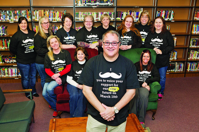 Dover Middle School Principal Donny Forehand, front, and his staff created T-shirts that asked, in a unique way, school patrons for their votes in the special millage election last week. Voters responded by approving the property-tax proposal to build a middle school complex. Also pictured, front row, from left, are Kay New, Karen Hill and Amanda Bryan; and back row, Vanessa George, Rhonda Parson, Rhonda Fairfield, Kim Williams, Catherine Pittman, Christi Jones, Paula Roberts and Suzy Pennington.