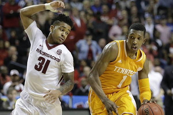Tennessee guard Josh Richardson (1) moves by Arkansas guard Anton Beard (31) during the second half of an NCAA college basketball game in the quarterfinal round of the Southeastern Conference tournament, Friday, March 13, 2015, in Nashville, Tenn. Arkansas won 80-72. (AP Photo/Mark Humphrey)
