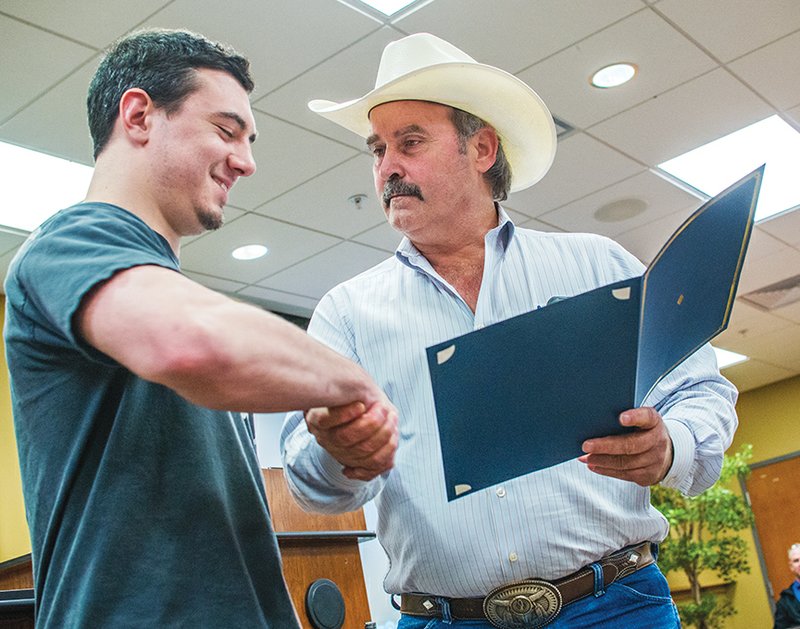 Jacob Miller shakes hands with County Judge Jerry Holmes during a reception for Miller at Arkansas State University-Heber Springs. Holmes proclaimed Wednesday as Jacob Miller Day to recognize him for placing third in a national welding competition.