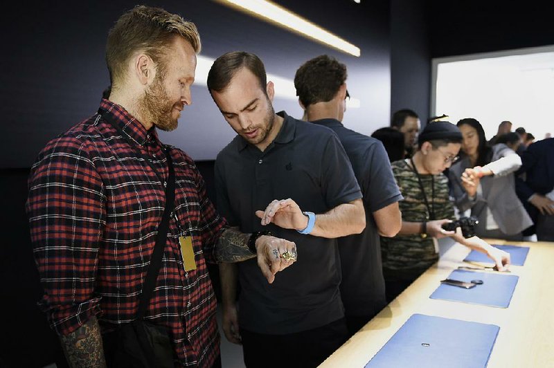 Personal trainer Robert “Bob” Harper, left, tries on the Apple Watch during the Apple Inc. Spring Forward event in San Francisco, California, U.S., last week. 