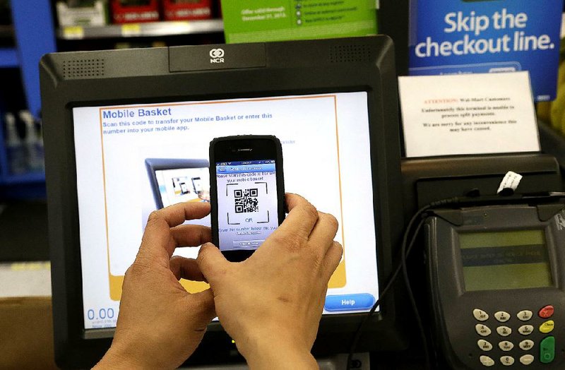 A Wal-Mart representative demonstrates a mobile payment application on a smartphone at a self-checkout register at a Wal-Mart store in San Jose, Calif. 