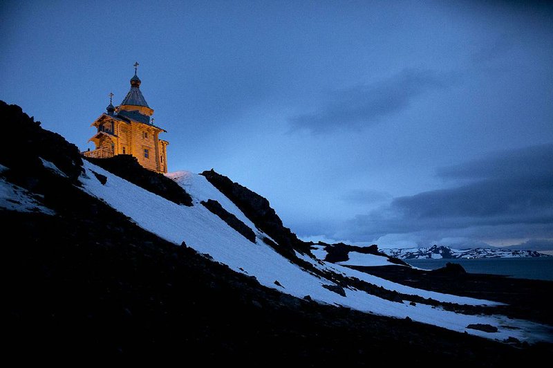 Holy Trinity Church is illuminated on King George Island, Antarctica. The clapboard church was first built in Russia, then disassembled and shipped log by log to Antarctica. 