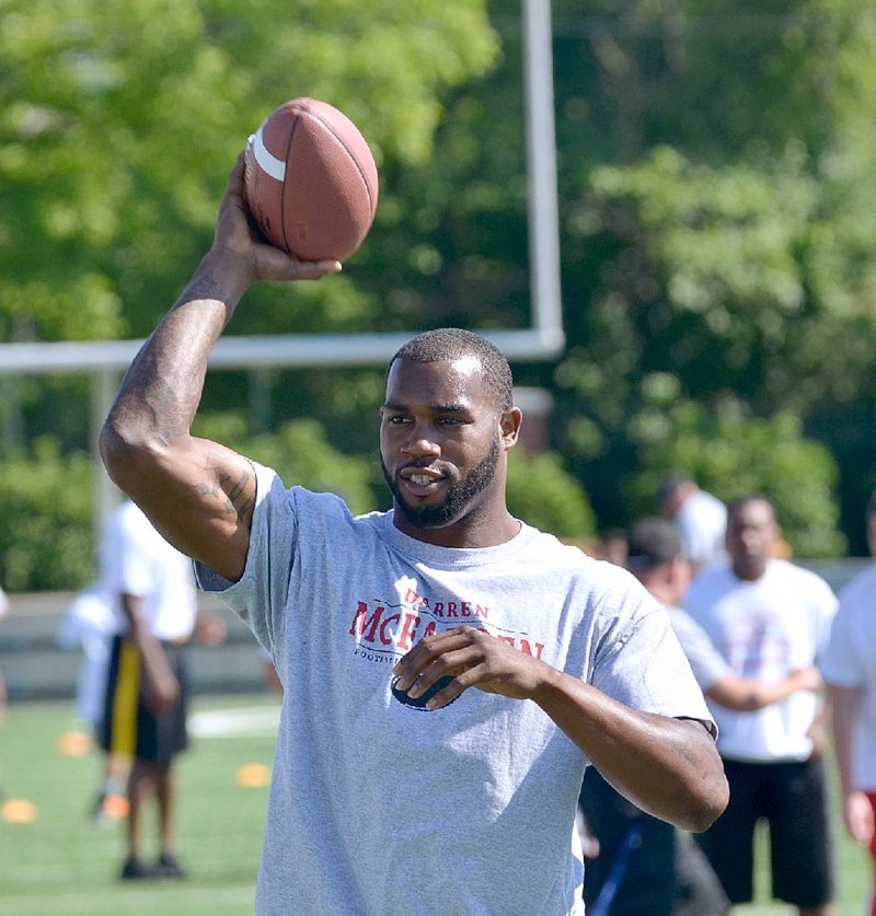 Former Razorback running back Darren McFadden throws the ball around with the kids during the Darren McFadden Football ProCamp at Jarrell Williams Bulldog Stadium in Springdale on this file photo.